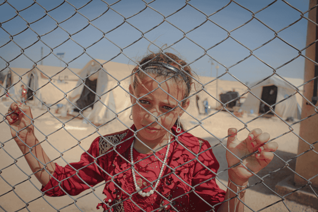 Jeune fille s’accrochant à un grillage à Idlib en Syrie