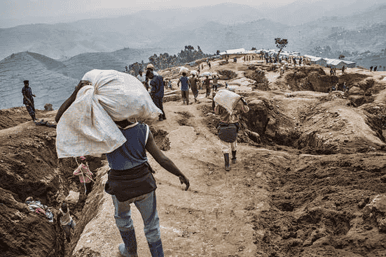 Un homme portant un sac dans une mine au congo